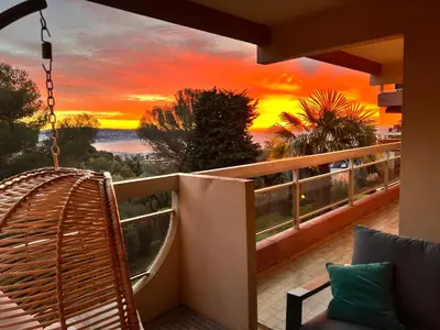 a sunset from a balcony with a rattan swing at La Vigie in Nice