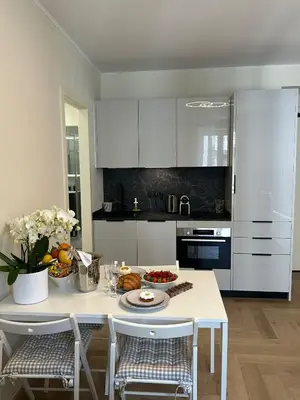 a kitchen with white cabinets and a table with food on it at Cozy Apartment in the heart of Nice in Nice