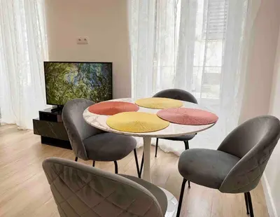 a room with a table with four chairs and a television at Nikaia Residence - 2BR Central Nice Close to Everything in Nice