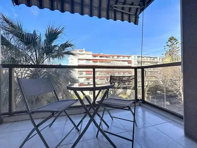 a table and chairs on a balcony with a view of a building at Appartement chic avec balcon Carré d Or Nice in Nice