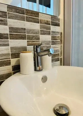 a bathroom sink with a faucet and two rolls of toilet paper at Studio Azur in Nice