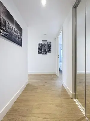 a hallway with white walls and a wooden floor at Comfort and relaxation and swimming pool in Nice
