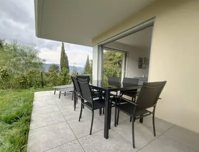a table and chairs on a patio with a view at Comfort and relaxation and swimming pool in Nice