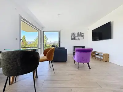 a living room with purple chairs and a tv at Comfort and relaxation and swimming pool in Nice