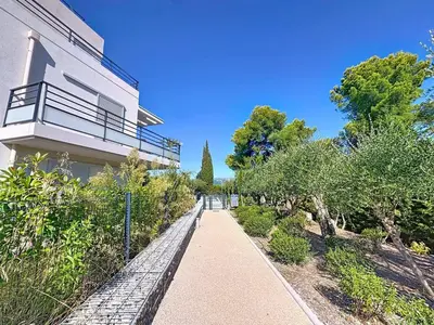 a walkway in front of a building with trees at Comfort and relaxation and swimming pool in Nice