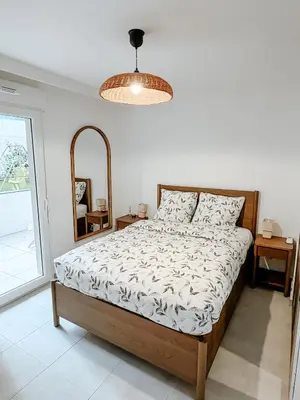 a white bedroom with a bed and a mirror at Aya - Renovated air-conditioned duplex with garden in Nice