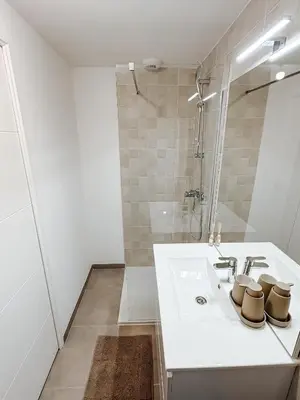 a white bathroom with a sink and a shower at Aya - Renovated air-conditioned duplex with garden in Nice