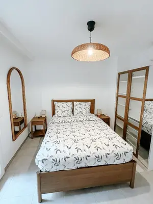 a bedroom with a bed and a chandelier at Aya - Renovated air-conditioned duplex with garden in Nice