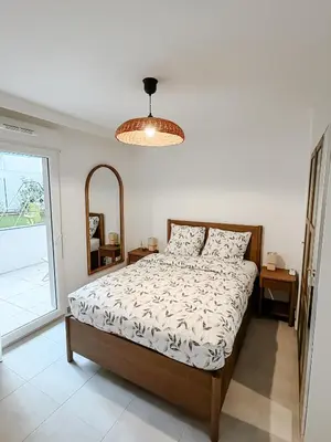 a bedroom with a bed and a large window at Aya - Renovated air-conditioned duplex with garden in Nice