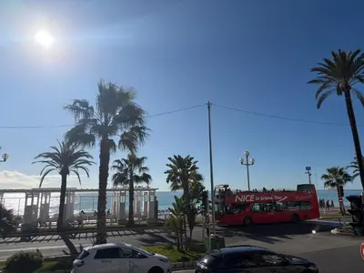 a red double decker bus in a parking lot near the beach at BLUE SKY Apartment in Nice