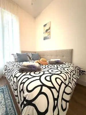 a bedroom with a black and white bed with a window at BLUE SKY Apartment in Nice