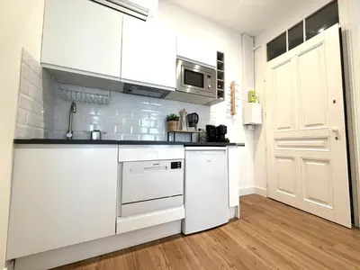 a kitchen with white cabinets and a white refrigerator at BLUE SKY Apartment in Nice