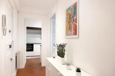 a white kitchen with a painting on the wall at Charme du Vieux-Nice - cocon lumineux à 100 m de la mer in Nice