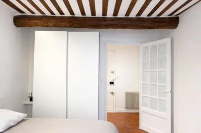 a bedroom with white walls and a striped ceiling at Charme du Vieux-Nice - cocon lumineux à 100 m de la mer in Nice