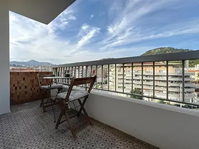 a balcony with two chairs and a table on a building at Évasion niçoise à 12 min du port Vue & confort in Nice