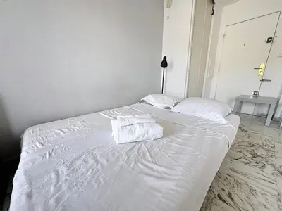 a white bed with two towels on top of it at Évasion niçoise à 12 min du port Vue & confort in Nice