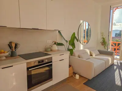 a kitchen with a couch and a stove top oven at Bright Artist's Apartment On Nice Hills in Nice