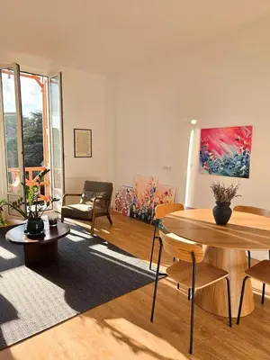 a living room with a table and a couch at Bright Artist's Apartment On Nice Hills in Nice