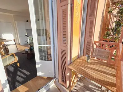 a balcony with a wooden bench on a building at Bright Artist's Apartment On Nice Hills in Nice