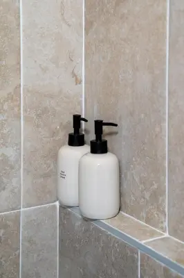 two white soap bottles sitting on a shelf in a bathroom at Elegant apartment - Haut Musiciens in Nice
