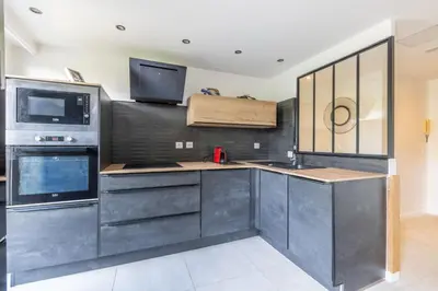 a kitchen with black cabinets and a sink and a microwave at Cagnes sur mer, 1 bedroom with Garden-Air conditioning-Wifi in Cagnes-sur-Mer
