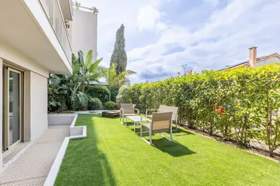 a garden with chairs and a table and grass at Cagnes sur mer, 1 bedroom with Garden-Air conditioning-Wifi in Cagnes-sur-Mer