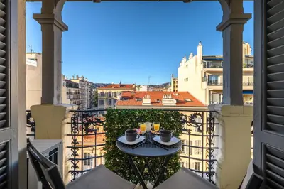 a table on a balcony with a view of a city at BelAzur - L'art de vivre au cœur de Nice in Nice