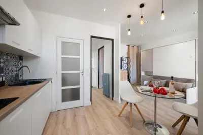 a kitchen and living room with a table and chairs at BelAzur - L'art de vivre au cœur de Nice in Nice