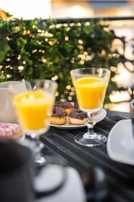 two glasses of orange juice and donuts on a table at BelAzur - L'art de vivre au cœur de Nice in Nice