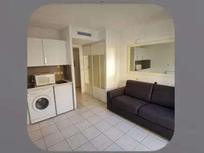 a living room with a couch and a microwave at Palais Des Domes Adagio Aparthotel in Nice
