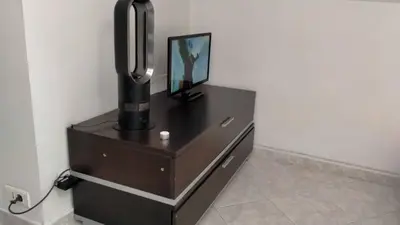 a dresser with a mirror and a picture on it at Charmant logement central in Nice