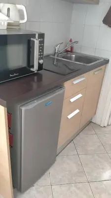 a kitchen with a sink and a microwave at Charmant logement central in Nice