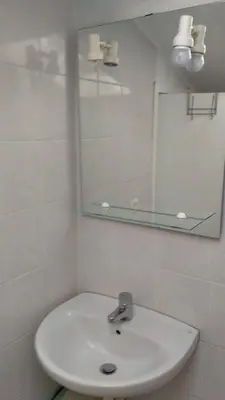 a white bathroom with a sink and a mirror at Charmant logement central in Nice