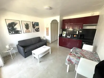 a living room with a couch and a kitchen at Studio port plage in Nice