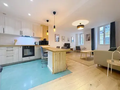 a kitchen and living room with a table and chairs at Séjour idéal au cœur du Vieux-Nice in Nice