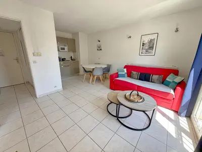 a living room with a red couch and a table at 4-person apartment - Air conditioning and Pool in Nice