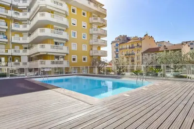 a swimming pool in front of a building at 4-person apartment - Air conditioning and Pool in Nice