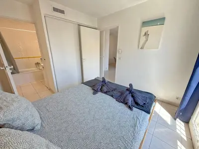 a bedroom with a bed with a blue blanket at 4-person apartment - Air conditioning and Pool in Nice