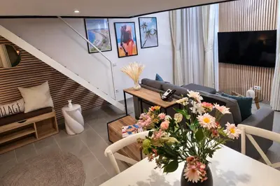 a living room with a table with a vase of flowers at Azur Carré d'or Duplex 6 pers 2 min de la mer in Nice