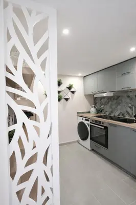 a kitchen with a white wall with a pattern at Azur Carré d'or Duplex 6 pers 2 min de la mer in Nice