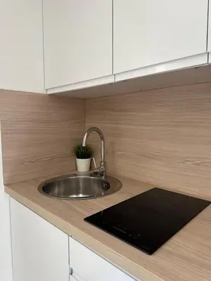 a kitchen counter with a sink and white cabinets at Studio - Nice Palais des Expositions in Nice
