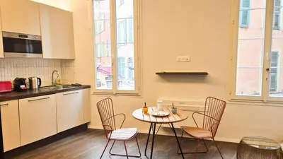 a kitchen with a table and chairs in a room at Grand studio cosy au cœur du Vieux-Nice in Nice