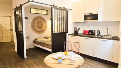 a small kitchen with a table and a small kitchen with a table and a room at Grand studio cosy au cœur du Vieux-Nice in Nice