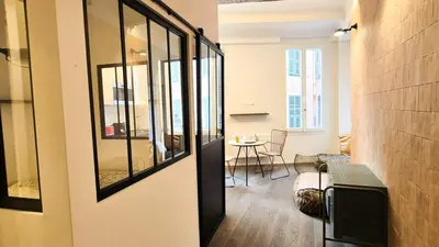 a living room with a mirror and a table at Grand studio cosy au cœur du Vieux-Nice in Nice