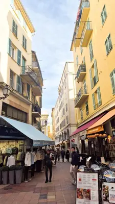 a group of people walking down a street with buildings at Grand studio cosy au cœur du Vieux-Nice in Nice