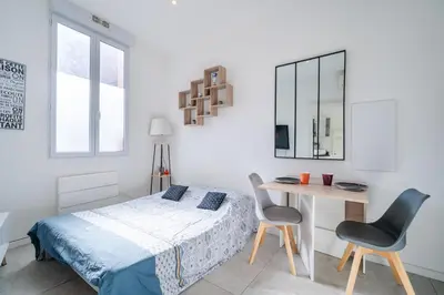 a bedroom with a bed and a table and chairs at Charmant studio cosy - Nice Est in Nice