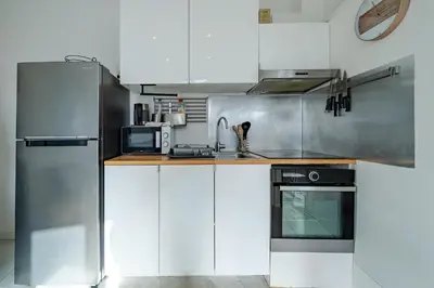 a kitchen with white cabinets and stainless steel appliances at Charmant studio cosy - Nice Est in Nice