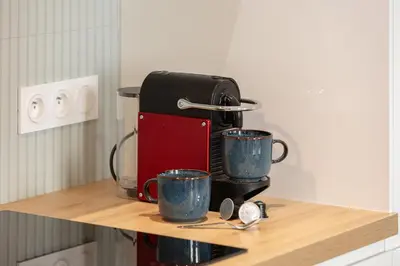 a coffee maker on a counter with two coffee cups at Élégant 2 pièces Niçois - Carré d'Or - Centre Ville - Mer à 2 min in Nice