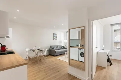 a kitchen and a living room with a table at Élégant 2 pièces Niçois - Carré d'Or - Centre Ville - Mer à 2 min in Nice