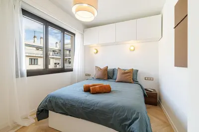 a bedroom with a bed with a large window at Appartement Mamabaldi in Nice